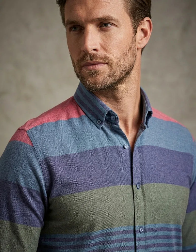 Man wearing a multicolored striped shirt against a neutral background