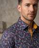 Man wearing a patterned shirt with a neutral background