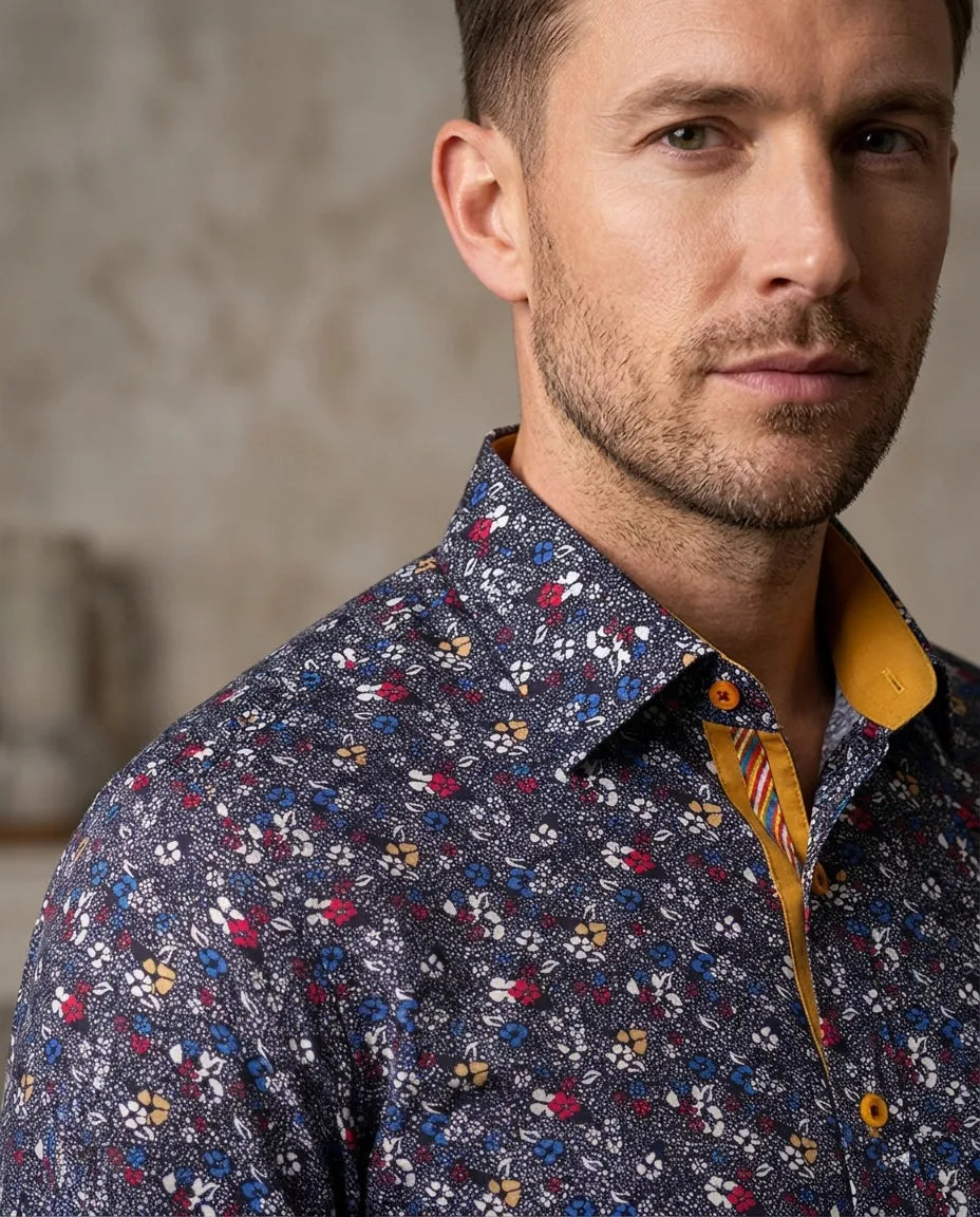 Man wearing a patterned shirt with a neutral background