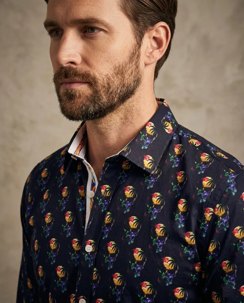 Man wearing a navy shirt with colorful floral pattern against a neutral background