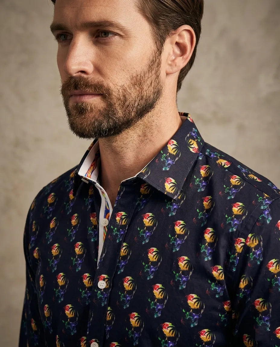 Man wearing a navy shirt with colorful floral pattern against a neutral background