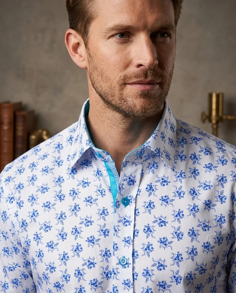 Man wearing a white shirt with blue floral pattern indoors