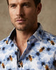 Man wearing a shirt with blue floral and bee pattern