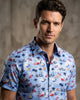 Man wearing a colorful patterned shirt against a neutral background