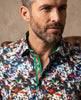 Man wearing a colorful patterned shirt against a neutral background