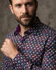 Man wearing a patterned shirt against a neutral background