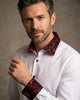 Man wearing a white shirt with red patterned collar and cuffs against a neutral background