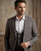 Man wearing a gray suit with a white shirt against a neutral background