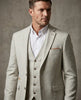 Man wearing a light gray checkered suit with a white shirt against a neutral background