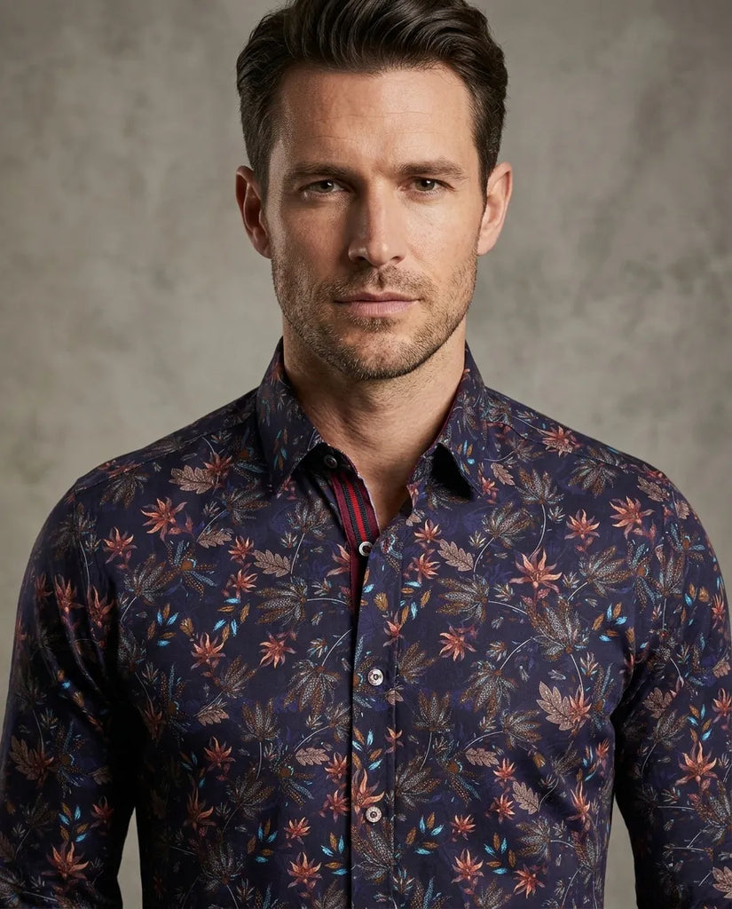 Man wearing a dark floral patterned shirt against a gray background