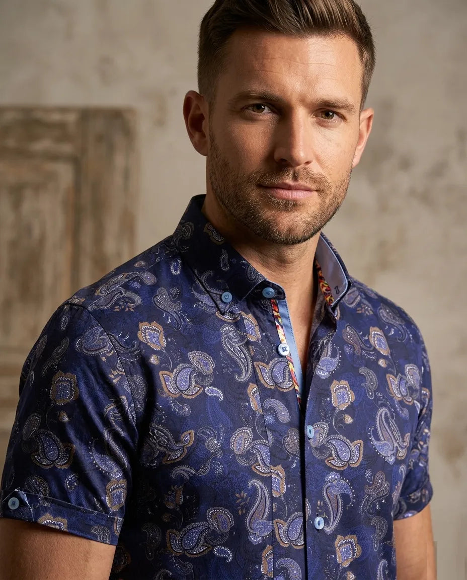 Man wearing a blue patterned shirt against a neutral background
