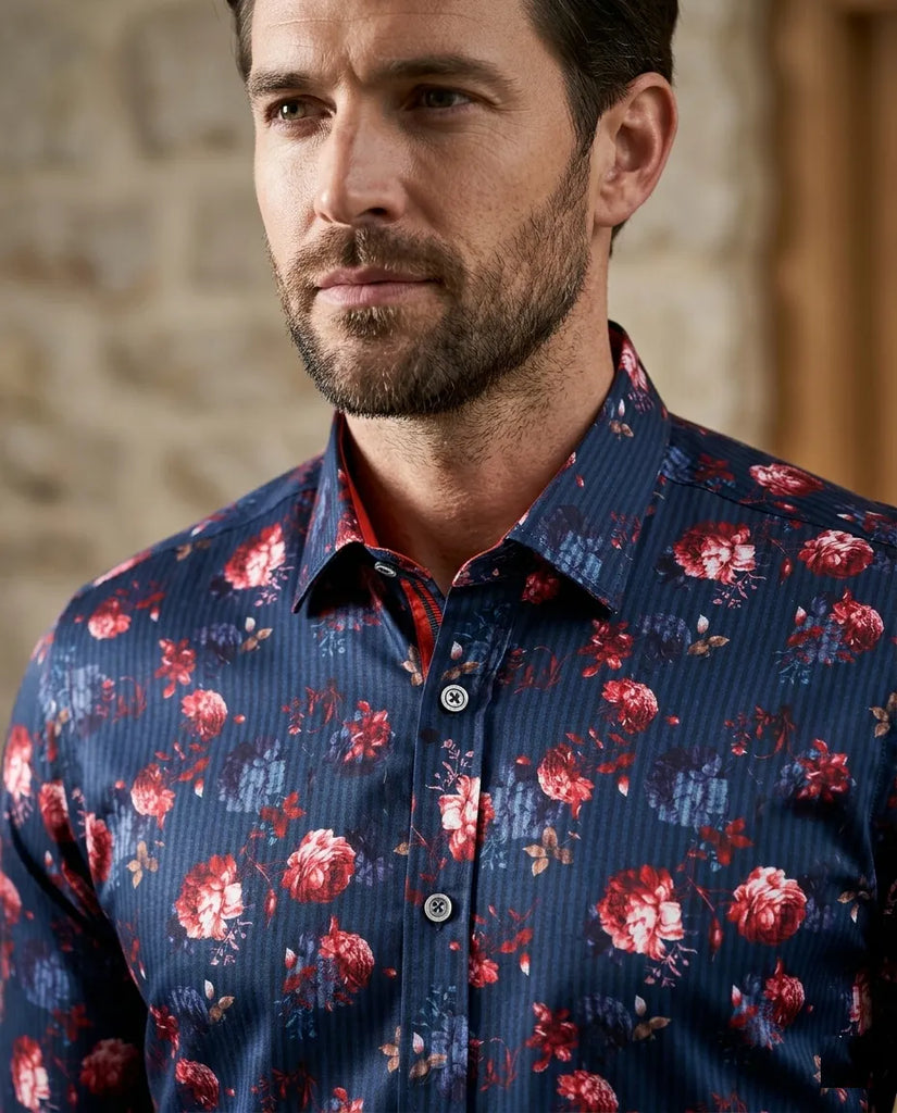Man wearing a blue floral shirt against a stone wall background