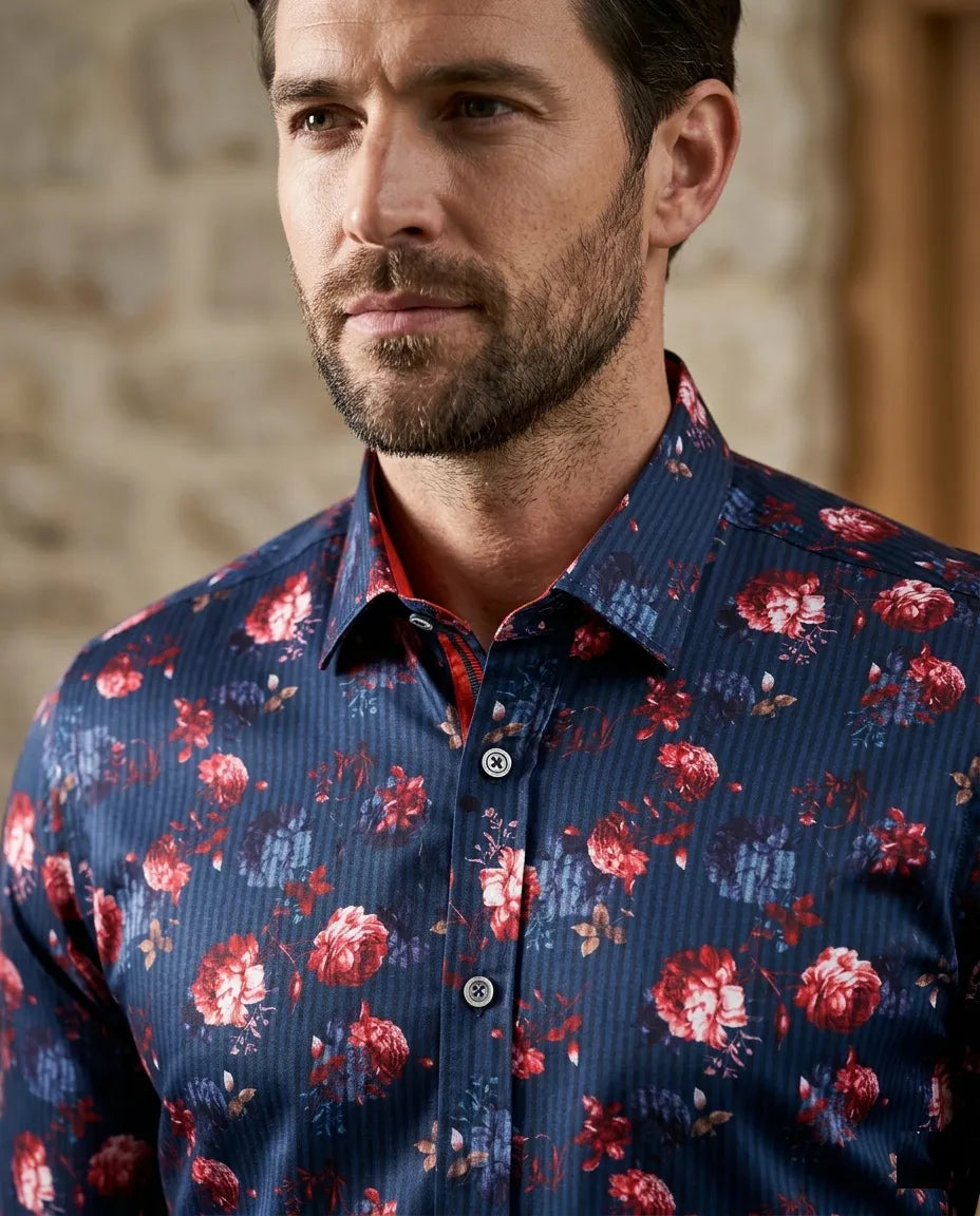 Man wearing a blue floral shirt against a stone wall background