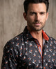 Man wearing a patterned shirt with a neutral background