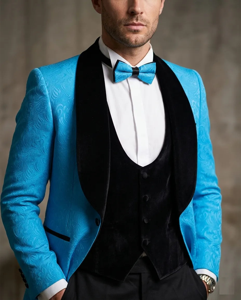 Man wearing a blue suit jacket with a black vest and bow tie against a neutral background