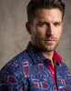 Man wearing a patterned shirt with a neutral background