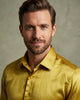 Man wearing a yellow satin shirt against a neutral background
