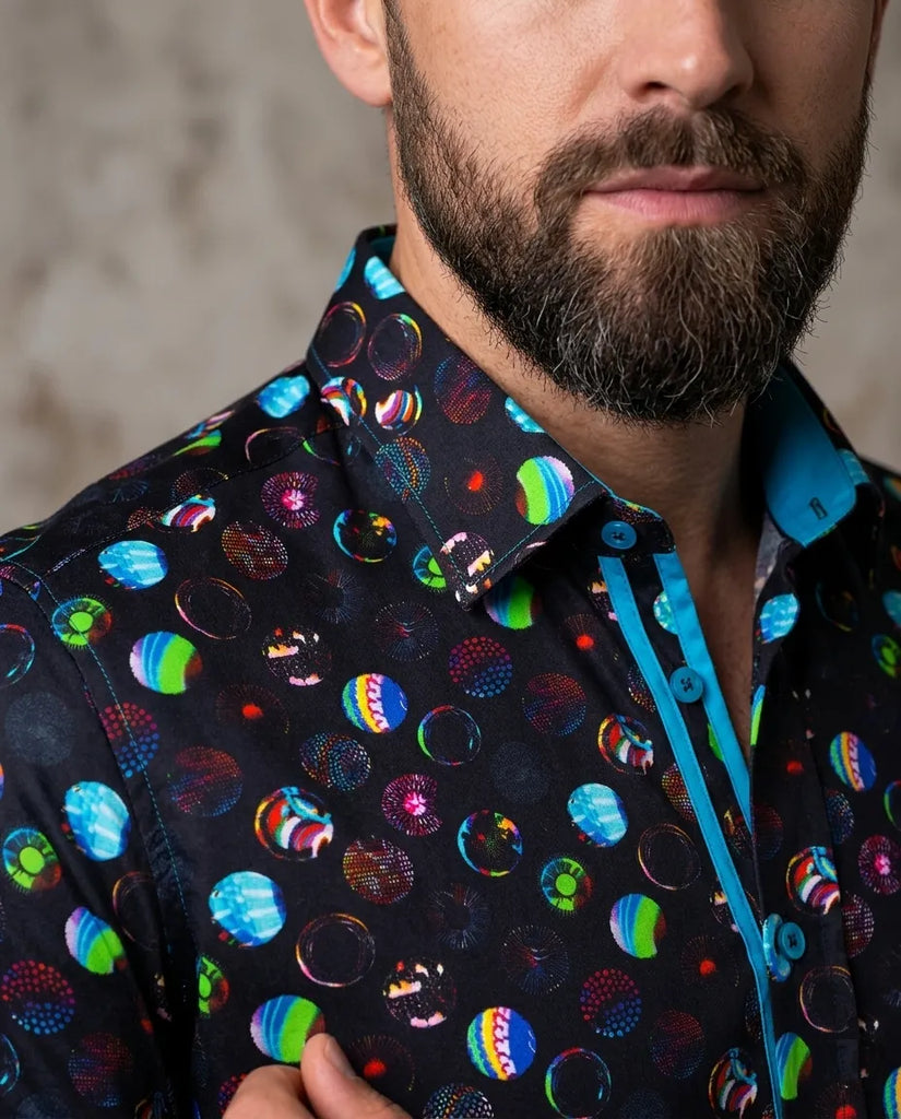 Man wearing a colorful patterned shirt with a blurred background