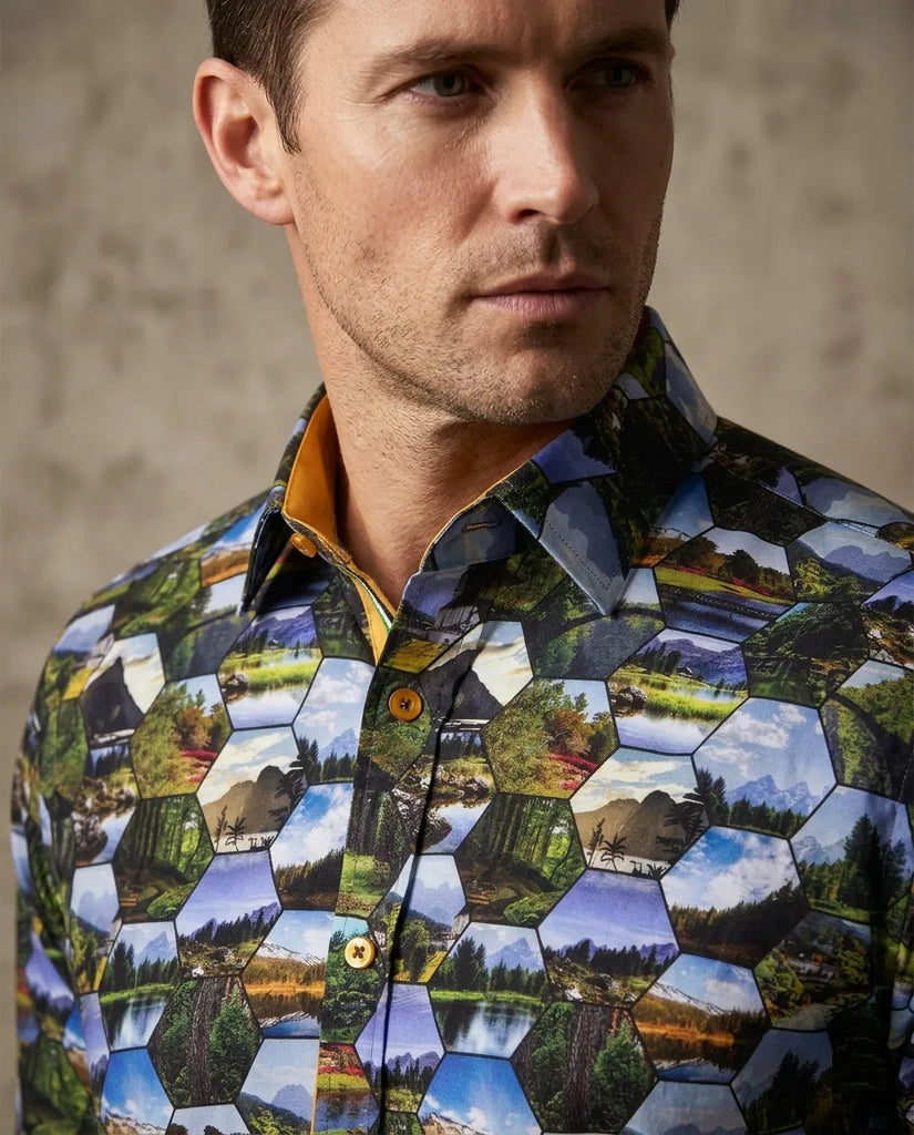 Man wearing a shirt with a geometric landscape pattern against a neutral background