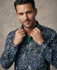 Man wearing a patterned shirt against a neutral background