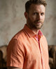 Man wearing an orange shirt with a blurred background