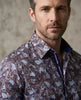 Man wearing a patterned shirt against a neutral background