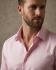 Man wearing a pink shirt against a neutral background