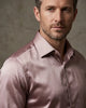 Man wearing a light pink dress shirt against a neutral background