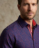 Man wearing a patterned shirt with a neutral background