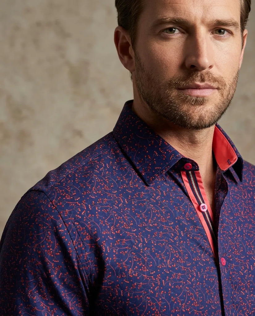 Man wearing a patterned shirt with a neutral background