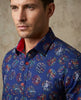 Man wearing a blue patterned shirt with a neutral background