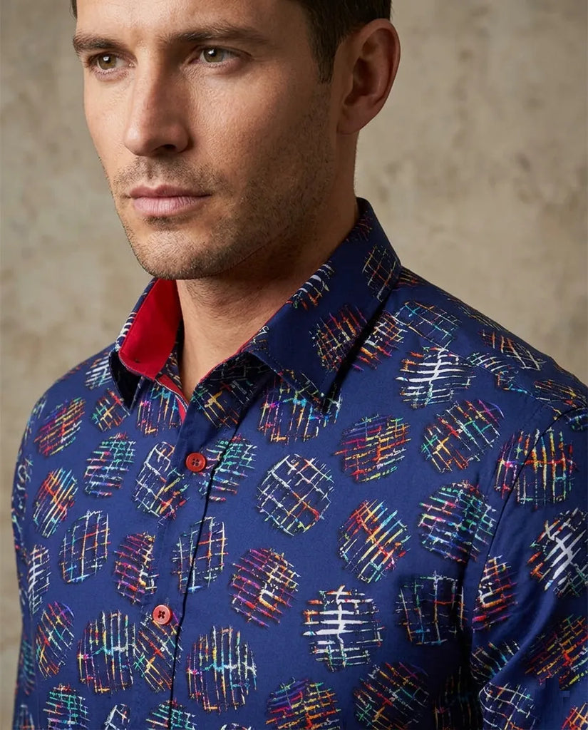 Man wearing a blue patterned shirt with a neutral background