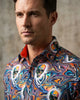 Man wearing a colorful, patterned shirt against a neutral background