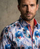 Man wearing a colorful patterned shirt against a neutral background
