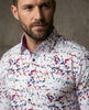 Man wearing a colorful abstract patterned shirt against a neutral background