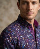 Man wearing a colorful floral-patterned jacket against a neutral background