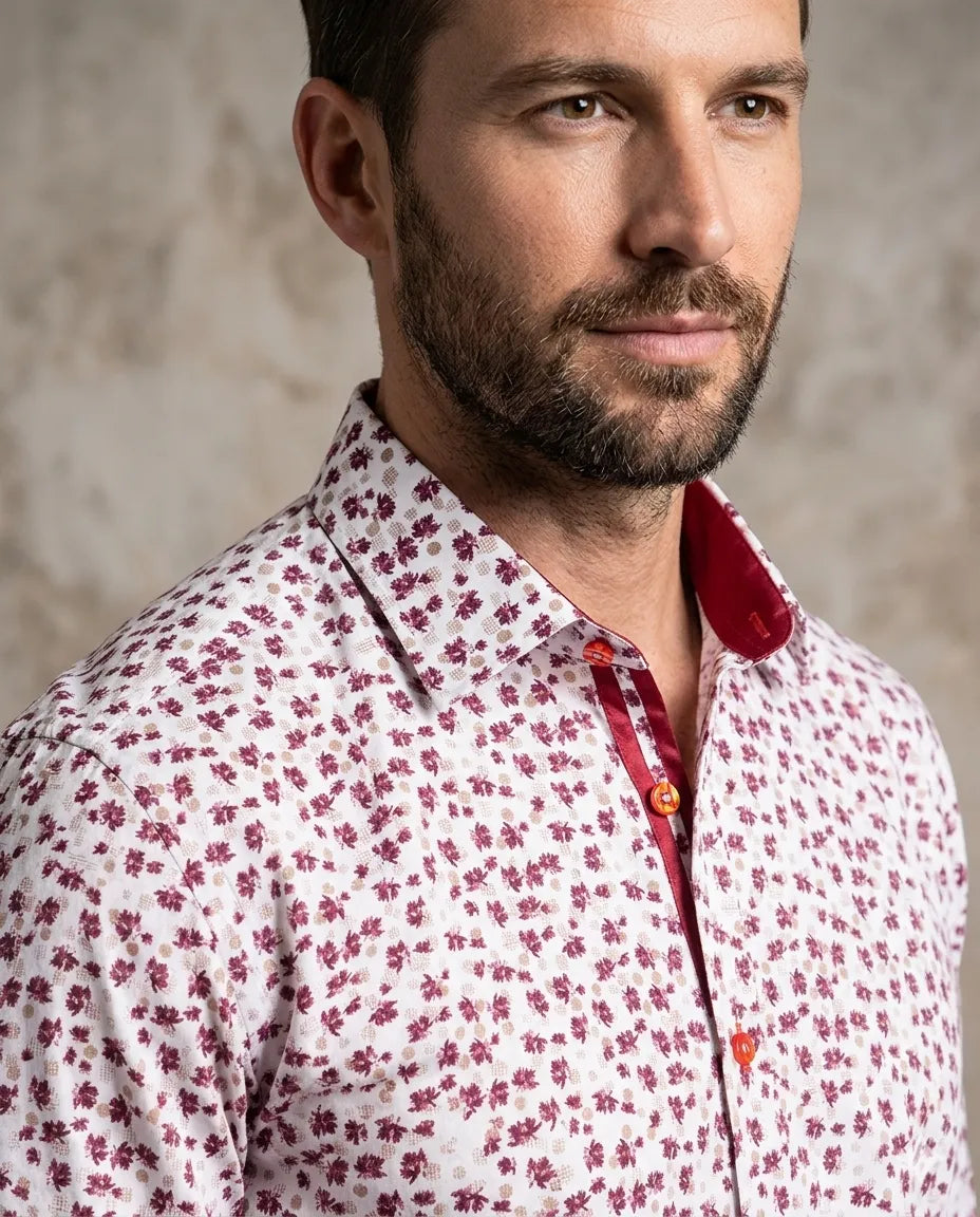 Man wearing a patterned shirt with a neutral background