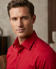 Man wearing a red shirt against a neutral background