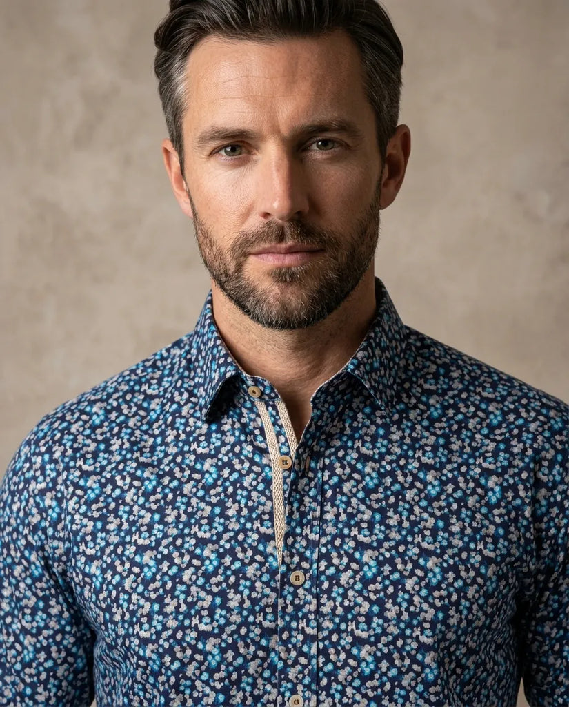 Man wearing a blue patterned shirt against a beige background
