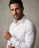 Man wearing a white dress shirt against a neutral background