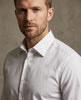 Man wearing a light gray dress shirt against a neutral background