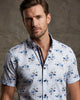 Man wearing a short-sleeve floral shirt against a neutral background