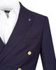 A close-up of a navy blue double-breasted blazer worn over a white dress shirt. The blazer features gold buttons and a small blue lapel pin, set against a plain white background.